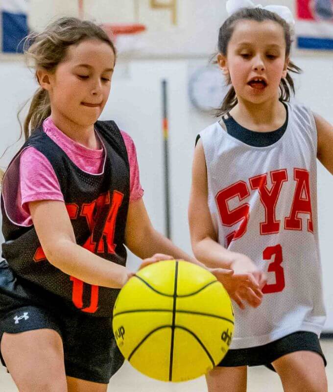 Two girls playing basketball