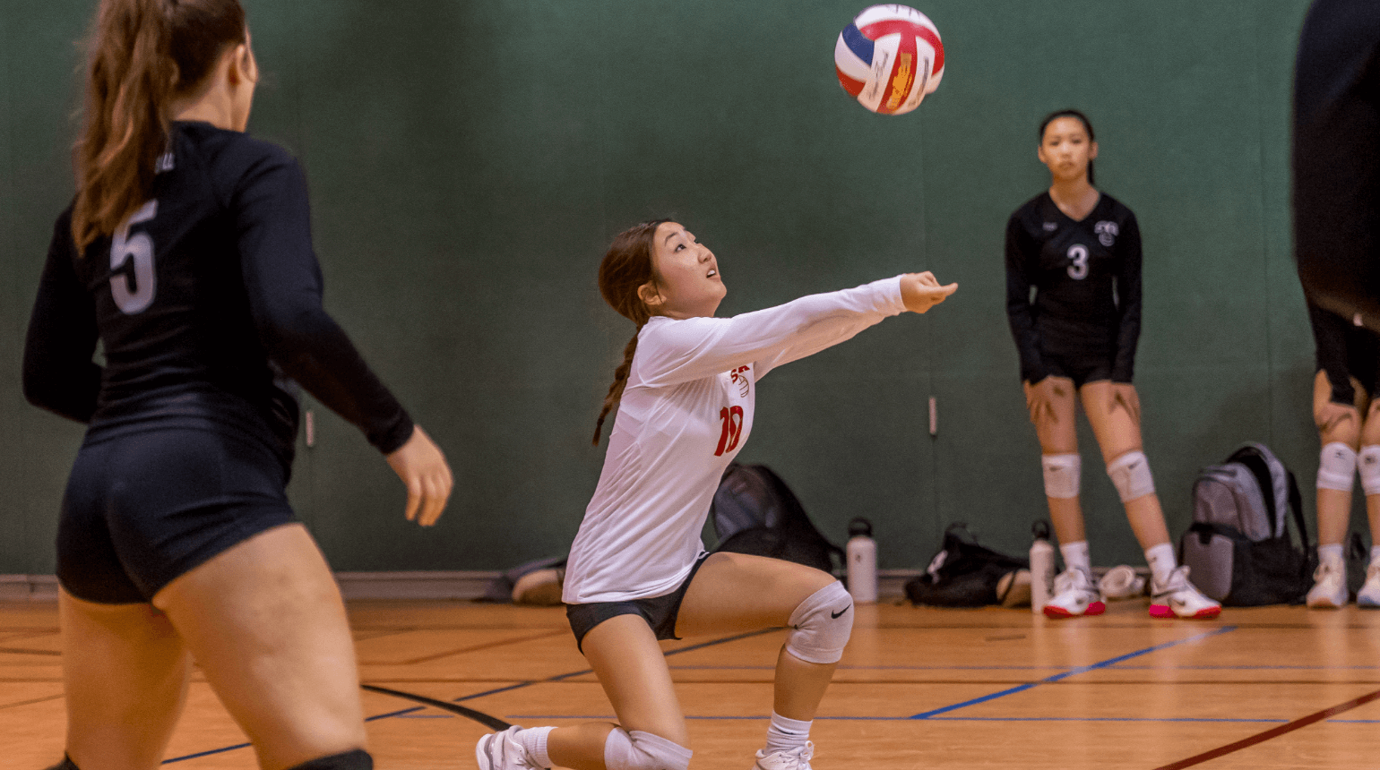 SYA House Volleyball girl kneeling to hit ball