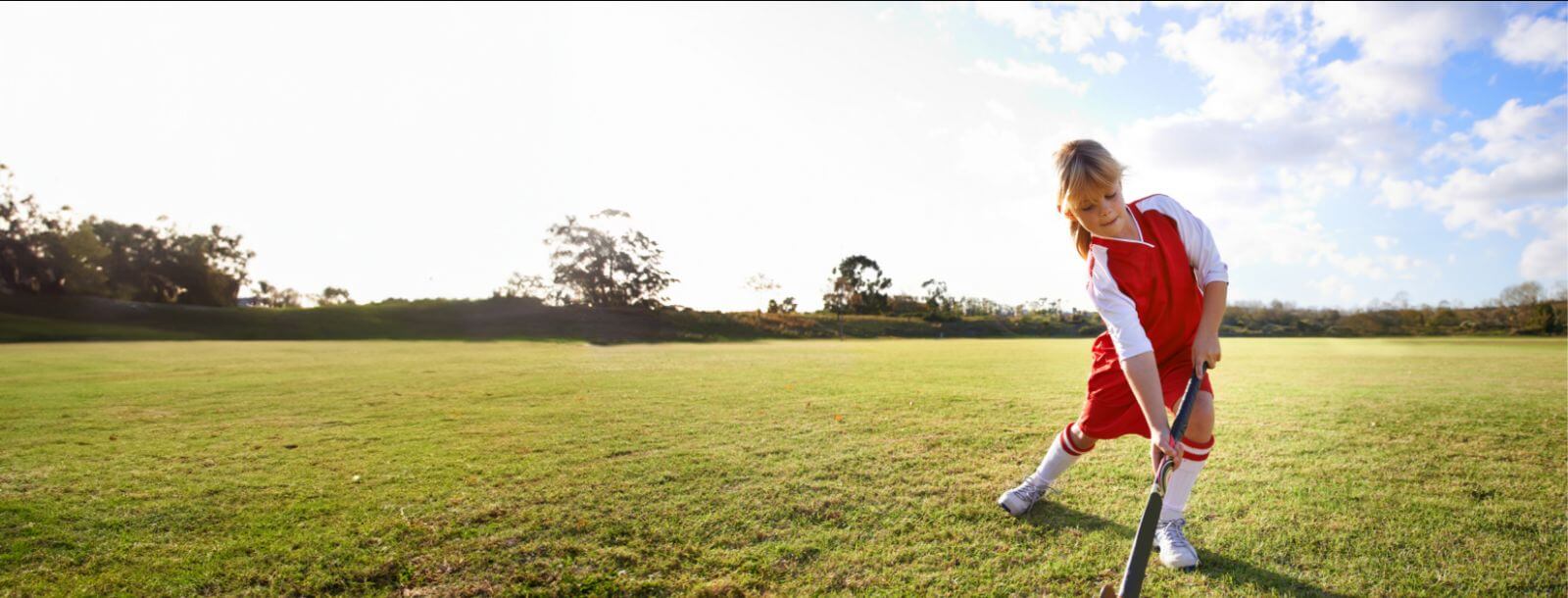 little girl playing field hockey