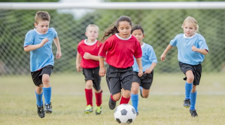 SYA recreational soccer players running on the field