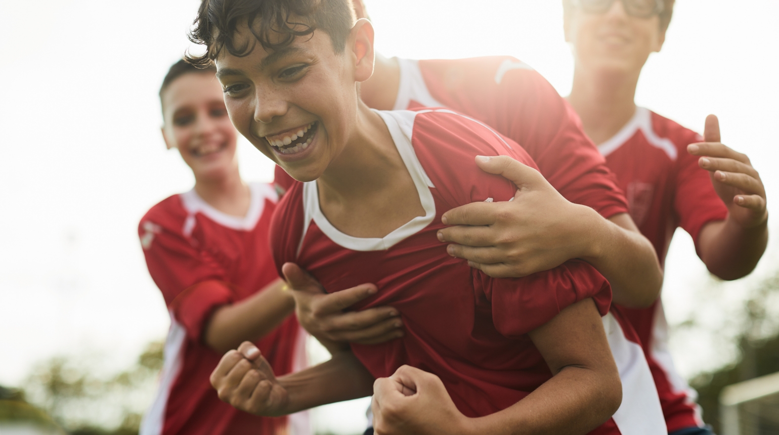 Boys celebrating together after making a soccer goal