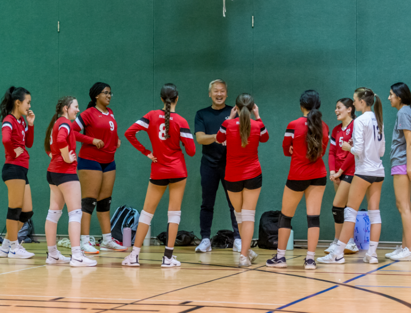 SYA Travel Volleyball players huddled with coach