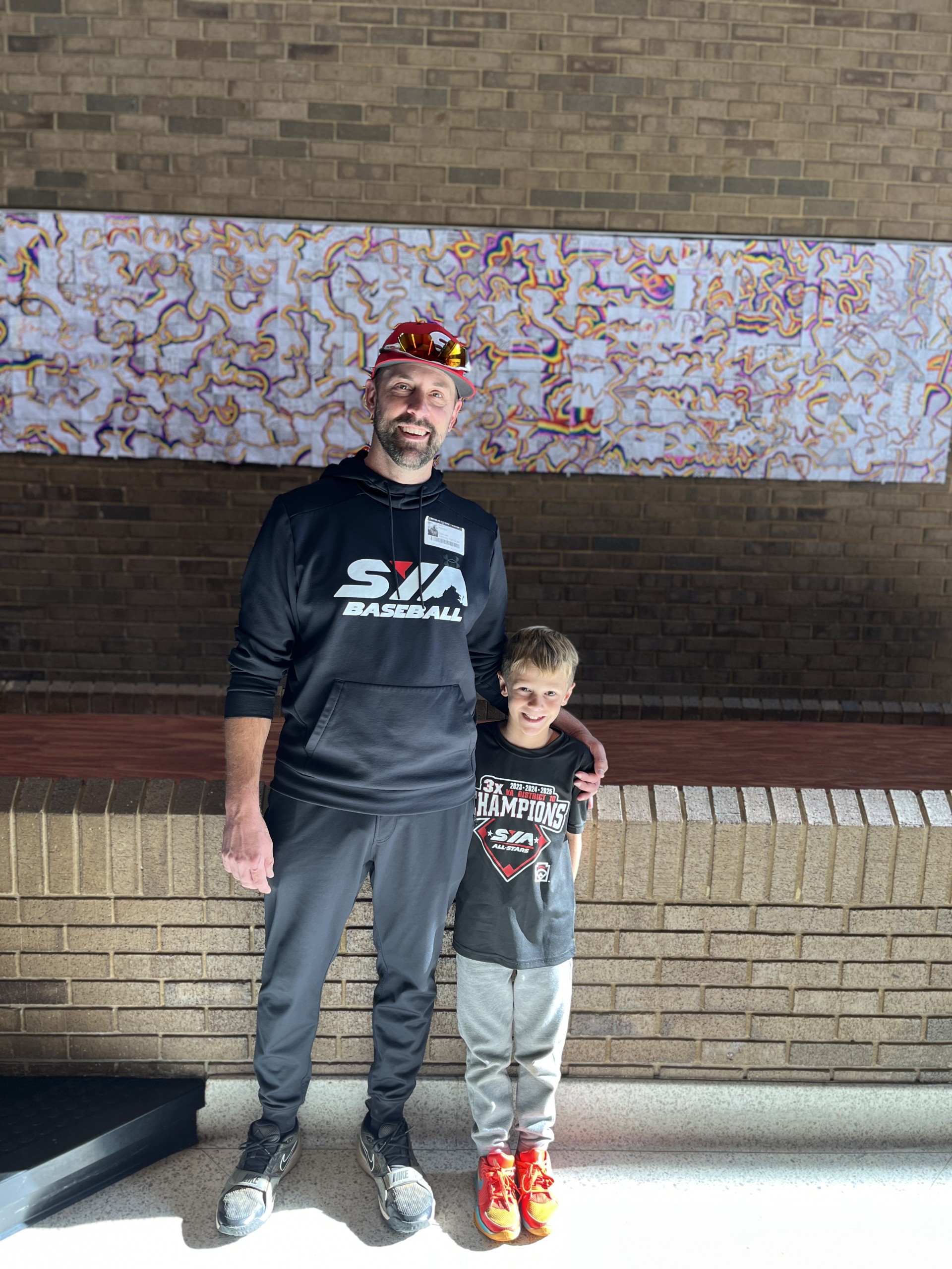 Little league coach posing with player