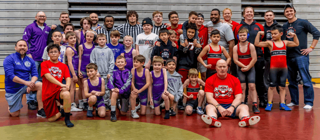SYA wrestlers stand with volunteer coaches