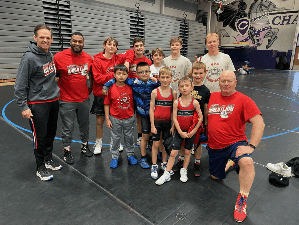 SYA wrestlers stand with volunteer coaches